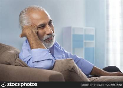 AN OLD MAN SITTING ALONE AT HOME AND THINKING