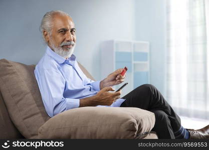 AN OLD MAN SITTING AT HOME AND DOING ONLINE TRANSACTIONS