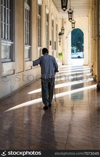 an old man with a cane on the sidewalk