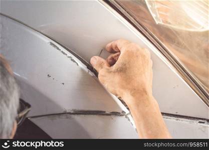 An old man with dirty hand fixing his car in Labour Day.