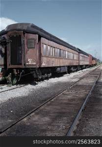 An old passenger train rotting away in a rail yard. 35mm film scan.