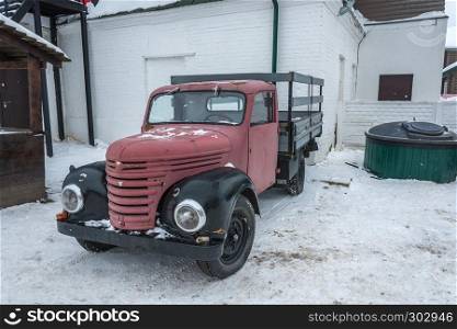 An old red truck on a winter day in the village of Vyatsky, Yaroslavl Region, Russia.