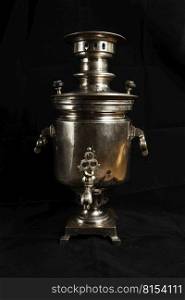 an old samovar isolated on a black background. Metal vessel for boiling water and making tea.Russian samovar.  old samovar.Metal vessel for boiling water and making tea.