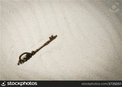 An old style key buried in the sand