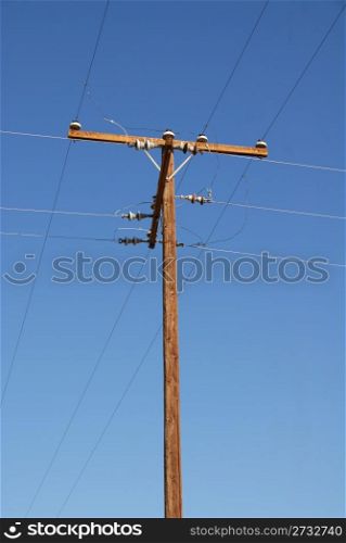 An old telephone pole against a blue sky