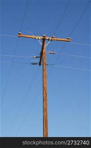 An old telephone pole against a blue sky