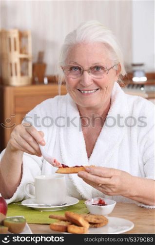An old woman eating breakfast.