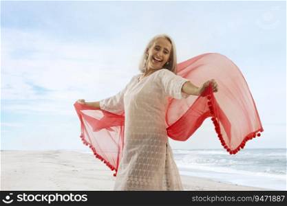 An old woman playing with her chunni on the beach.