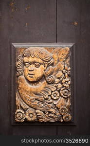 An old wood carving of an angel on a street door in Prague in the Czech Republic.