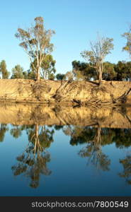 an old wooden house amongst the trees on the river murray. old murray building