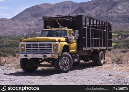 an old yellow truck to transport animals