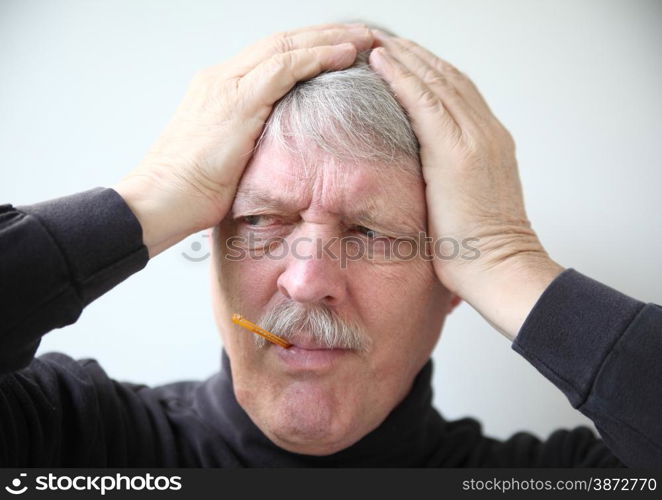 An older man holds his head while taking temperature.