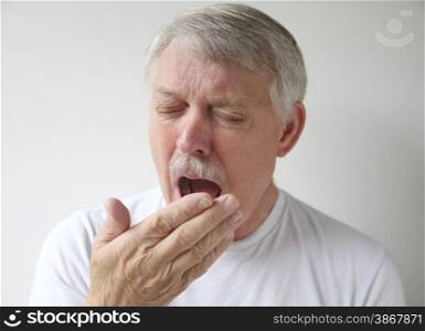 an older man just before yawning or sneezing