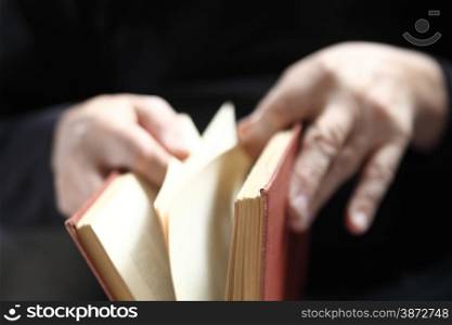 An older man leafs through an old book.