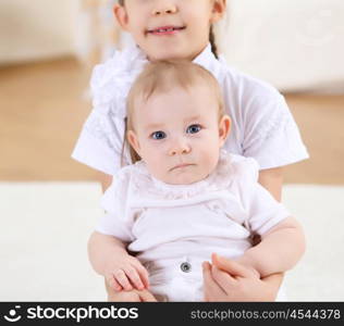 an older sister playing with a toddler sister at home