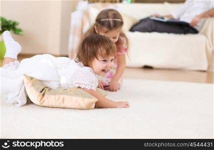 an older sister playing with a toddler sister at home