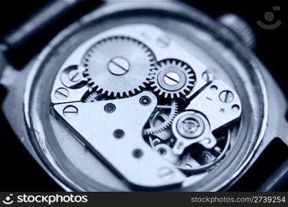 an open mechanical watch, macro, blue toning
