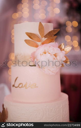 An original high wedding cake decorated with flowers and leaves.. Stylish wedding cake with leaves 3817.