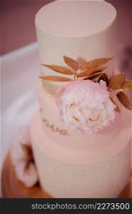 An original high wedding cake decorated with flowers and leaves.. Stylish wedding cake with leaves 3818.