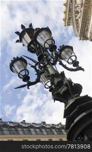 An ornamental street light outside the Opera in Paris, with its typical cast iron lamp post and glass casings