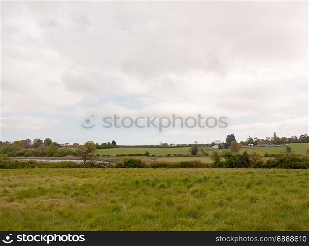 an overcast and cloudy countryside scene outside in an open field