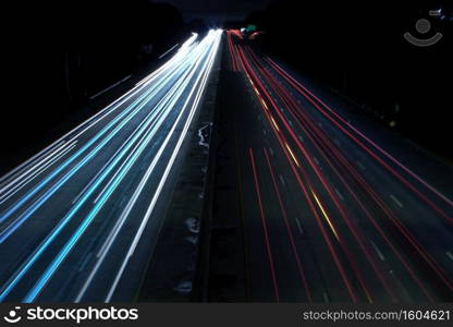 An overhead shot of a highway road with car light speed trails. Overhead shot of a highway road with car light speed trails