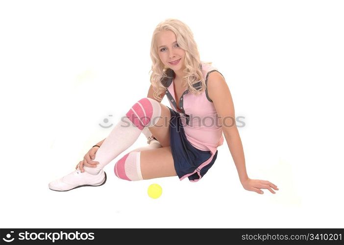 An portrait of a gorgeous teenager with curly blond hair and blue eyes,sitting on the floor in a tennis outfit, for white background.
