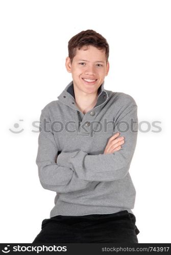An smiling young handsome teenage boy sitting in a gray sweater with his arms crossed, isolated for white background