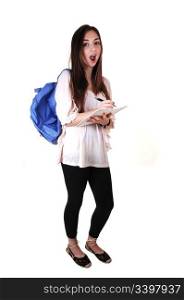 An surprised teenager with a blue backpack over her shoulder in anbeige blouse and black tights, with a notebook in her hand, over white.