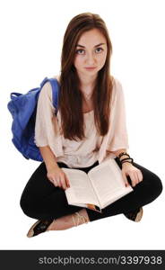 An teenager sitting on the floor with a blue backpack over her shoulderin a blouse and black tights, with a book on her lap, for white background.