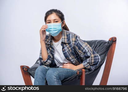 An uncomfortable woman sitting on a chair and wearing a mask