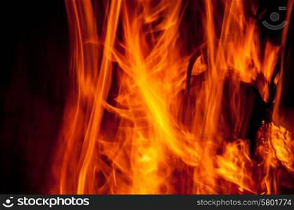 An up close view of the flames of a camp fire, revealing the orange, yellow and red colours of the chemical reaction.