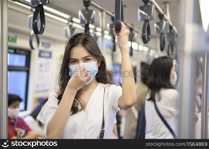 An young woman is wearing protective mask in metro , covid-19 protection , safety travel , new normal , social distancing , safety transportation , travel under pandemic concept .. An young woman is wearing protective mask in metro , covid-19 protection , safety travel , new normal , social distancing , safety transportation , travel under pandemic concept