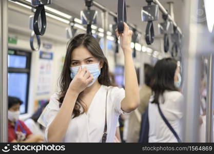 An young woman is wearing protective mask in metro , covid-19 protection , safety travel , new normal , social distancing , safety transportation , travel under pandemic concept .. An young woman is wearing protective mask in metro , covid-19 protection , safety travel , new normal , social distancing , safety transportation , travel under pandemic concept