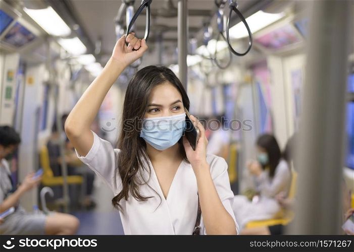 An young woman is wearing protective mask in metro , covid-19 protection , safety travel , new normal , social distancing , safety transportation , travel under pandemic concept .. An young woman is wearing protective mask in metro , covid-19 protection , safety travel , new normal , social distancing , safety transportation , travel under pandemic concept
