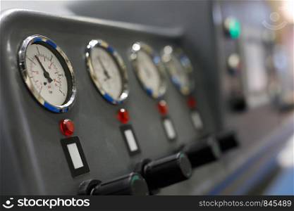 Analog manometers on a control panel of industrial machine. Selective focus.