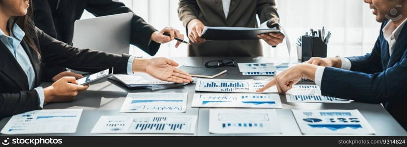 Analyst team working on BI Fintech to analyze financial dashboard paper at office workplace. Businesspeople reviewing report paper on table for business insight. Panorama shot. Prodigy. Analyst team analyzing business data paper on office table. Prodigy