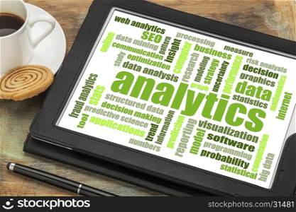 analytics and data analysis word cloud on a digital tablet with a cup of coffee