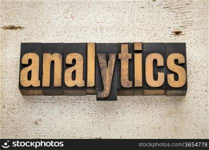 analytics word in vintage letterpress wood type on a grunge painted barn wood background