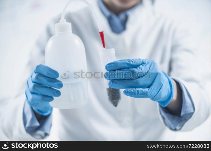 Analyzing Plant Samples for Presence of Pesticides in Farming Products. Pouring Water into Test Tube with Dissolved Samples in Laboratory. Analyzing Plant Samples for Presence of Pesticides in Farming Products