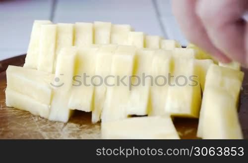 Ananasstucke werden vom Koch mit einem Messer von einem Holzbrett genommen, chef picks up pineapple slices with a knife