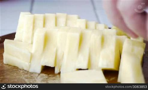 Ananasstucke werden vom Koch mit einem Messer von einem Holzbrett genommen, chef picks up pineapple slices with a knife