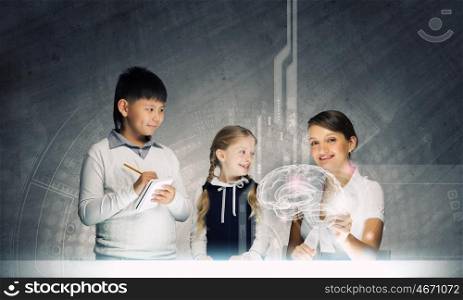Anatomy lesson. Young teacher and her pupils examining hologram of human brain