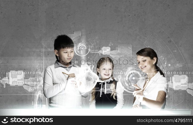 Anatomy lesson. Young teacher and her pupils examining hologram of human heart