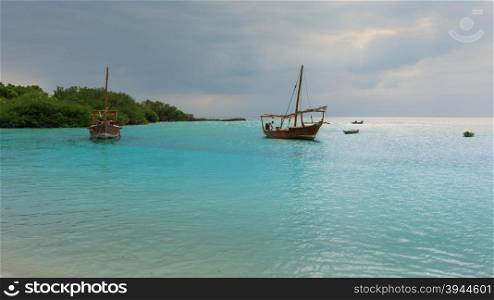 Anchored wooden dhow boats on the amazing turquoise water in the Indian ocean Zanzibar, Tanzania.