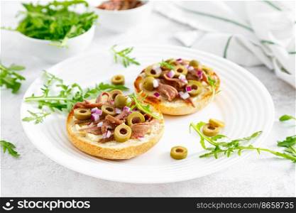Anchovy toasts with olives and arugula