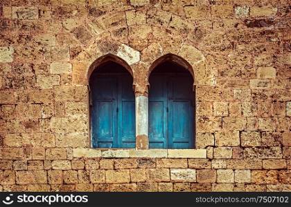Ancient architecture background, two little windows with blue wooden shutters among great stony wall, house of God, old monastery, Lebanon