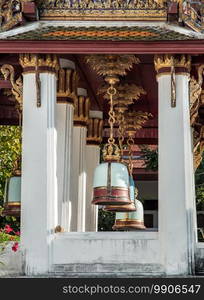 Ancient bells hanging on pillars outside in the thai temple. Thai temple bell which believe that who knock this bell will get the good luck, Selective focus.