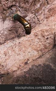 ancient bronze faucet and old wall