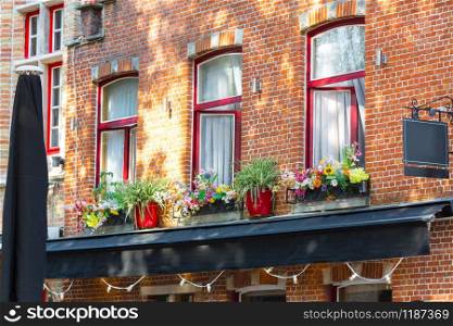 Ancient building facade with flowers, old provincial European town. Summer tourism and travels, famous europe landmark, popular places for vacation tour or holidays
